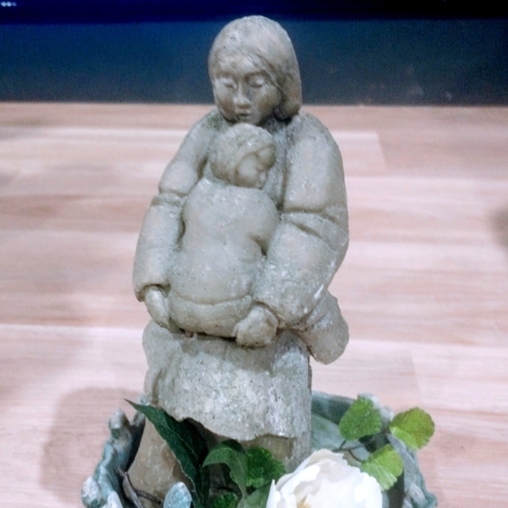 Sculpture of Eskimo mom with baby on stand